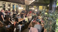 a crowd of people sitting at tables in a restaurant